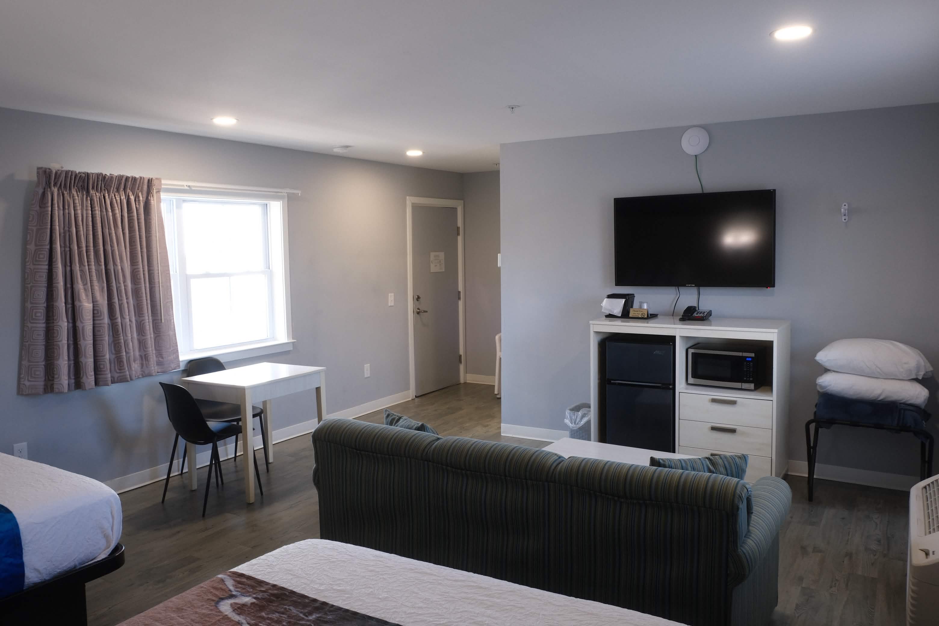 Room with flat-screen TV, mini fridge, and microwave